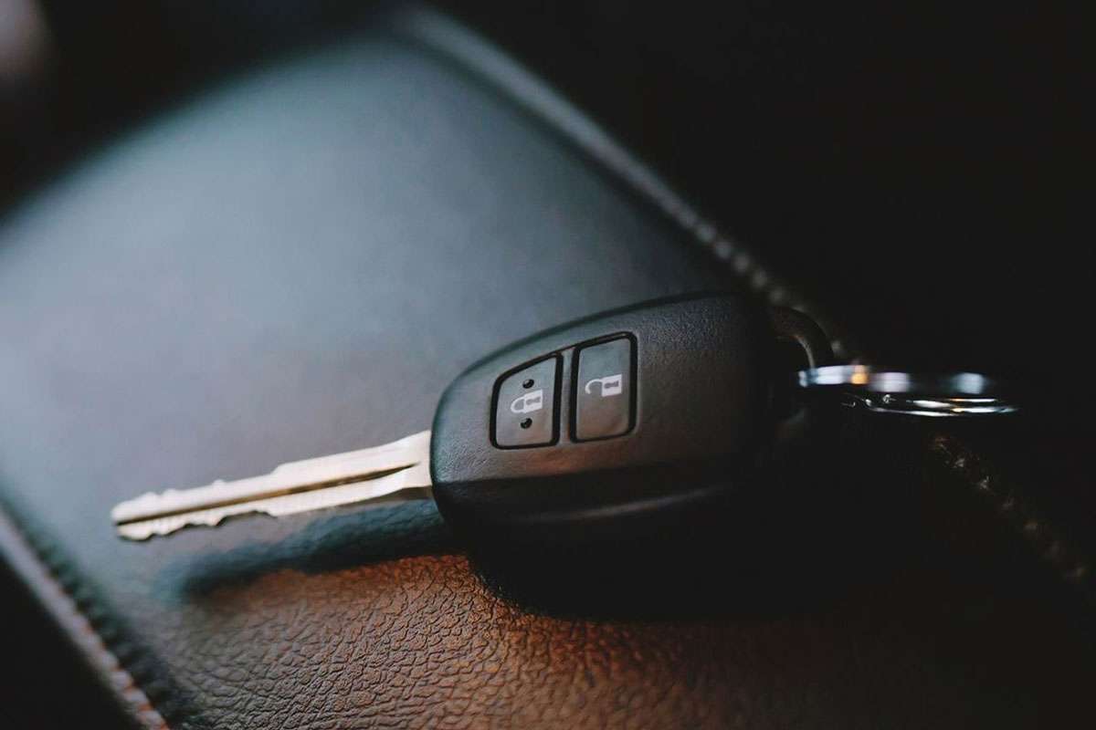Car key fob on leather surface.